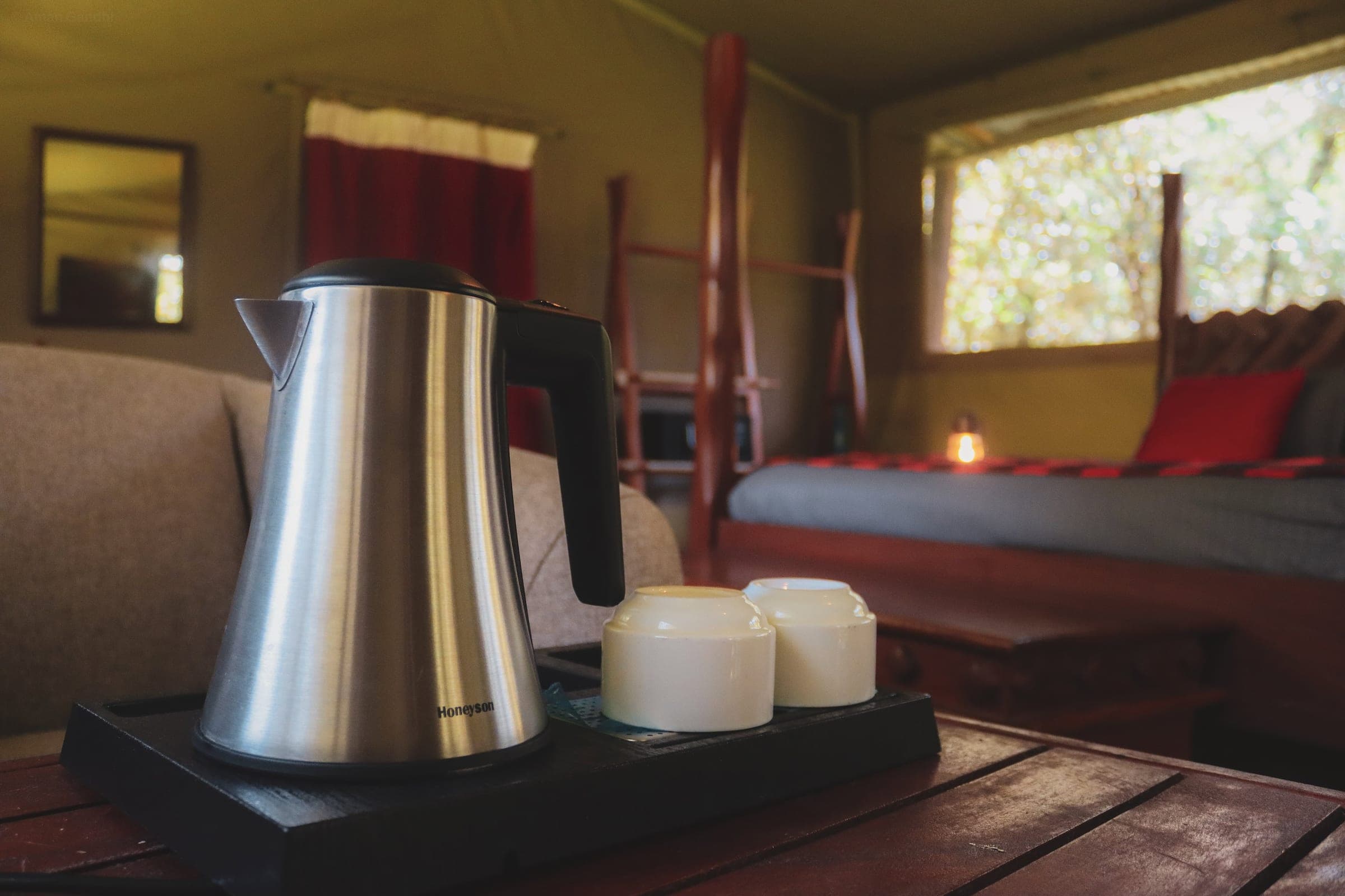 Tea tray with kettle and cups in the Double Tent, the four-poster bed soft behind