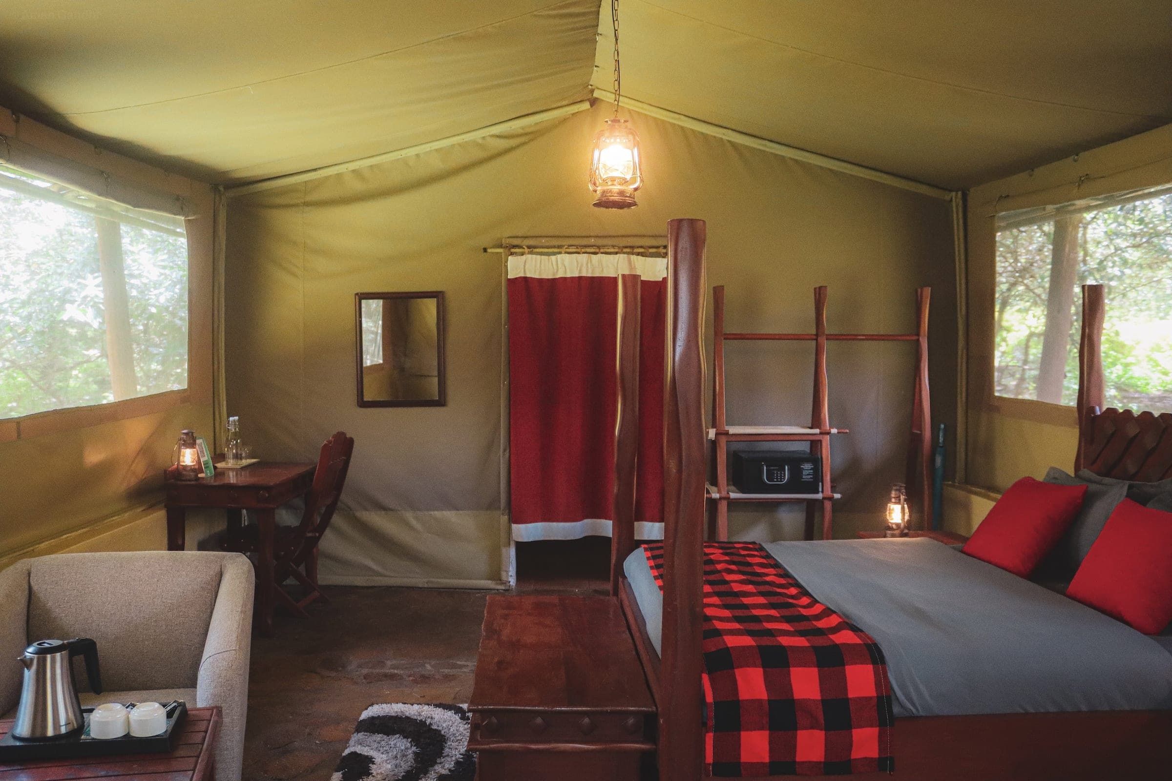 Inside the Double Tent: armchair with tea tray, writing desk and dressing area under a hanging lantern